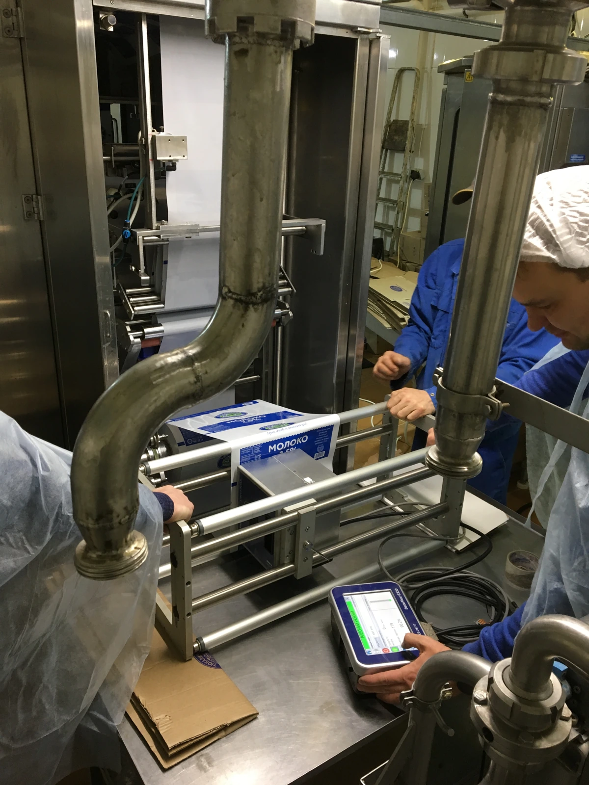 Engineers fitting the marking onto a live dairy line